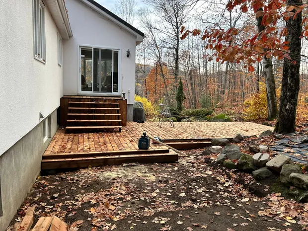 Le patio neuf terminé, avec un large escalier de cinq marches devant la porte-fenêtre