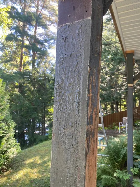 Poteau de galerie : la grande face grise est encore écaillée, et une bande de bois neuf apparaît sur l'arête là où le sablage a passé